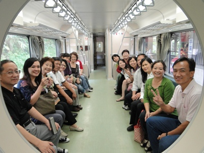 (右圖)楊主任(左1)與廖隊長(左後2)志工們於平溪小火車內開心合影